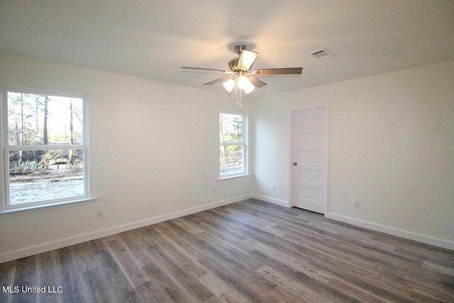 unfurnished room featuring hardwood / wood-style floors, ceiling fan, and a healthy amount of sunlight