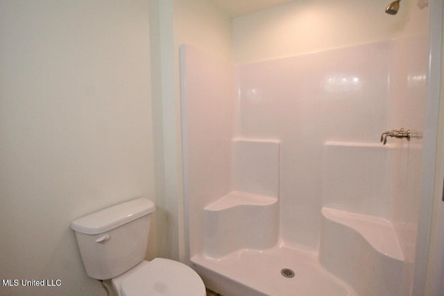 bathroom featuring a shower and toilet