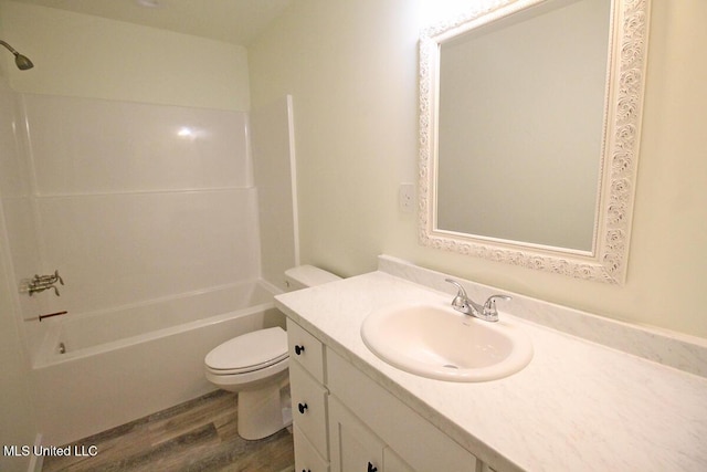 full bathroom featuring washtub / shower combination, vanity, hardwood / wood-style flooring, and toilet