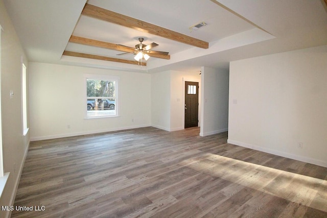 spare room with a tray ceiling, ceiling fan, and hardwood / wood-style flooring