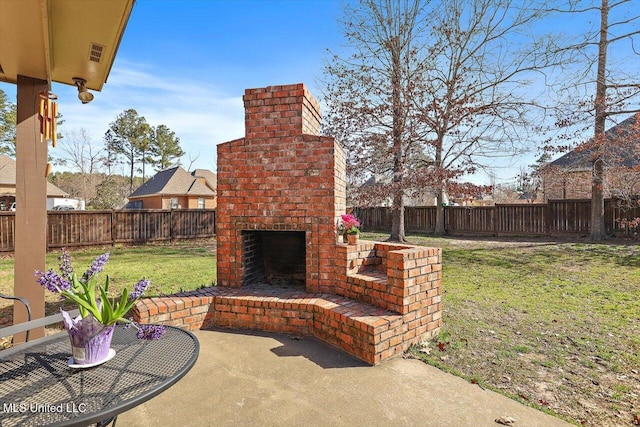 view of patio / terrace featuring visible vents, a fenced backyard, and an outdoor brick fireplace