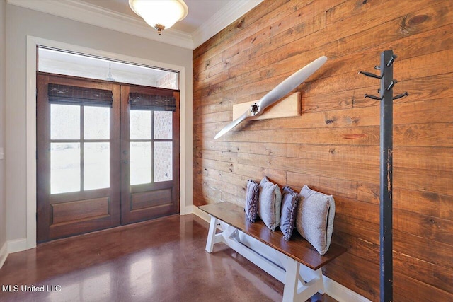 foyer with french doors, concrete flooring, and ornamental molding