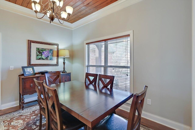 dining space with a notable chandelier, crown molding, baseboards, and wood finished floors