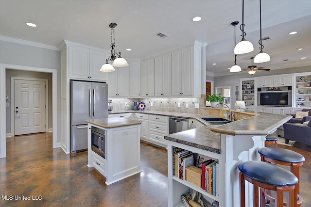 kitchen with visible vents, ornamental molding, stainless steel appliances, a sink, and open floor plan