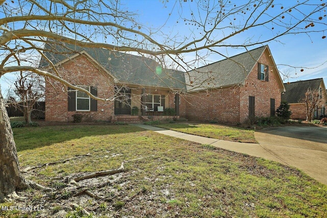 traditional-style home with brick siding and a front lawn