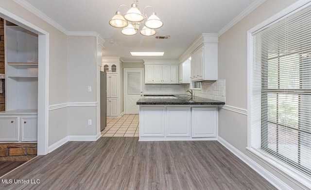 kitchen with freestanding refrigerator, visible vents, a chandelier, white cabinets, and light wood-type flooring