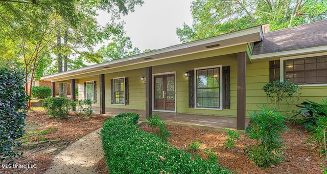 entrance to property with a porch and french doors