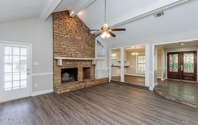 unfurnished living room with french doors, a stone fireplace, lofted ceiling with beams, dark hardwood / wood-style flooring, and ceiling fan