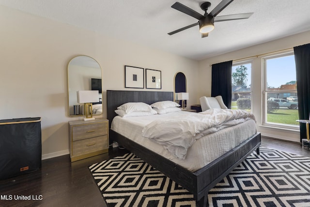 bedroom featuring a textured ceiling, wood finished floors, and baseboards