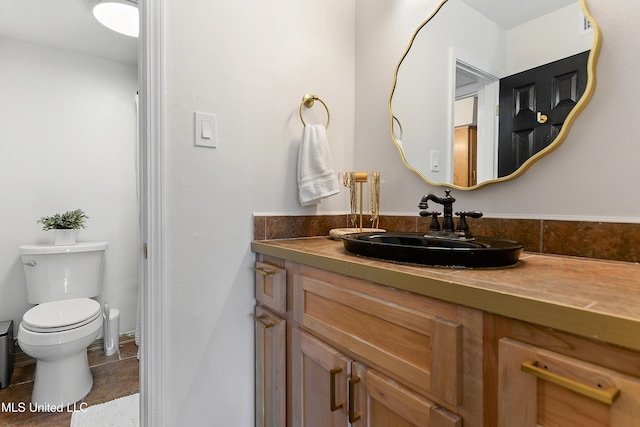 bathroom featuring toilet, tile patterned flooring, and vanity