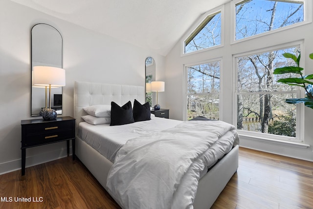 bedroom with high vaulted ceiling, dark wood-style flooring, and baseboards