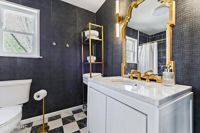 bathroom featuring tile patterned floors, vanity, toilet, and baseboards