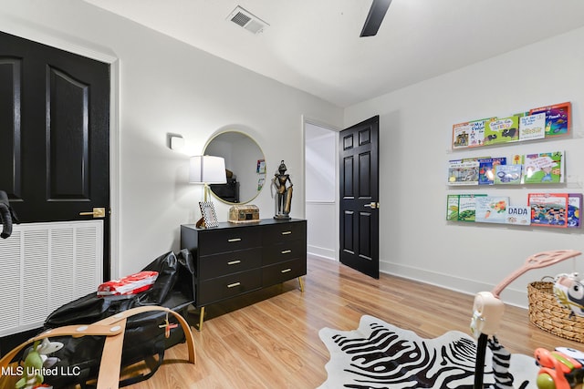 bedroom with light wood finished floors, baseboards, visible vents, and ceiling fan