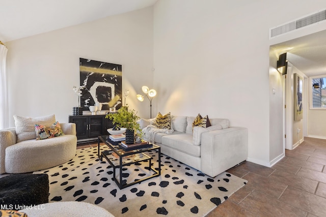 living area featuring high vaulted ceiling, baseboards, and visible vents