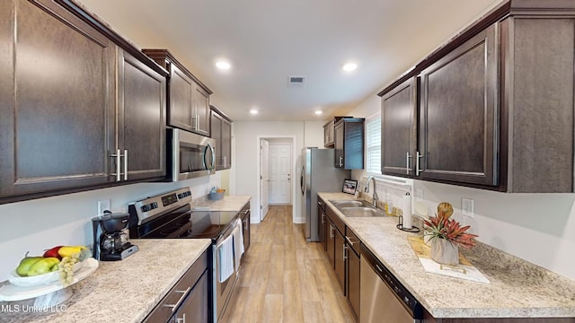 kitchen featuring dark brown cabinets, stainless steel appliances, light hardwood / wood-style floors, and sink