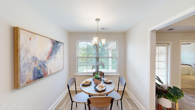 dining space featuring an inviting chandelier and light hardwood / wood-style flooring