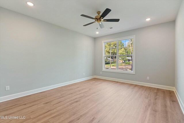 empty room with ceiling fan and light hardwood / wood-style floors