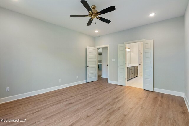 unfurnished bedroom featuring light hardwood / wood-style floors, ceiling fan, and ensuite bathroom