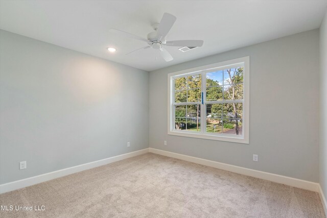 carpeted spare room with ceiling fan