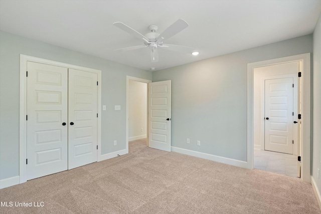 unfurnished bedroom featuring ceiling fan, light carpet, and a closet