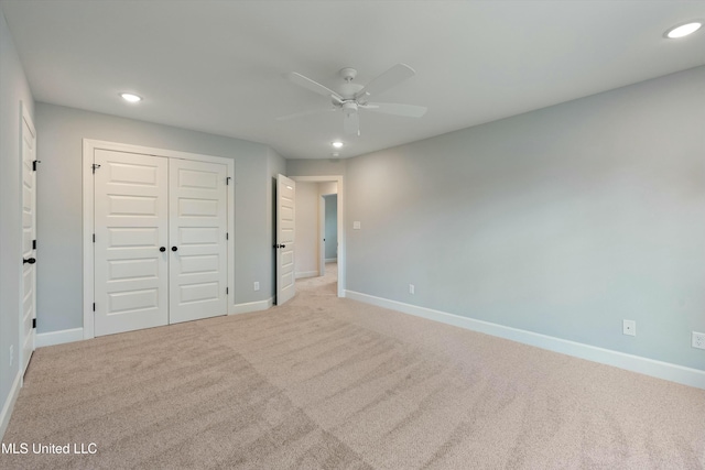 unfurnished bedroom with ceiling fan, a closet, and light carpet