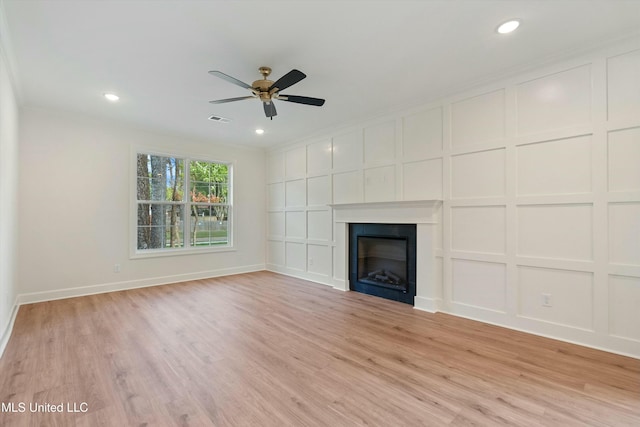 unfurnished living room with light hardwood / wood-style floors, ceiling fan, and ornamental molding