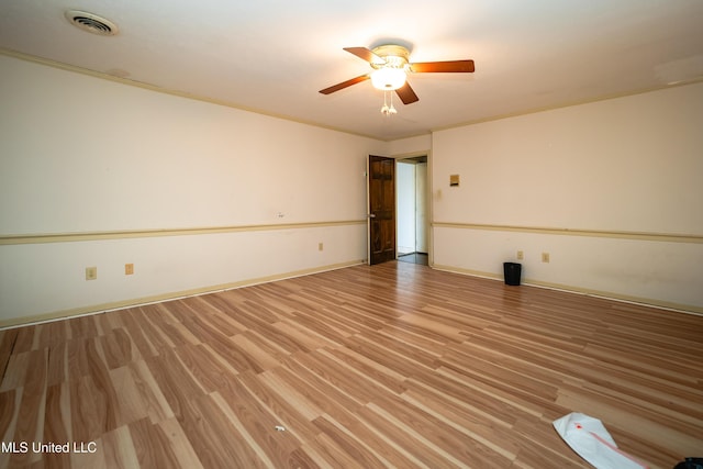 unfurnished room featuring light wood-type flooring, ceiling fan, visible vents, and baseboards