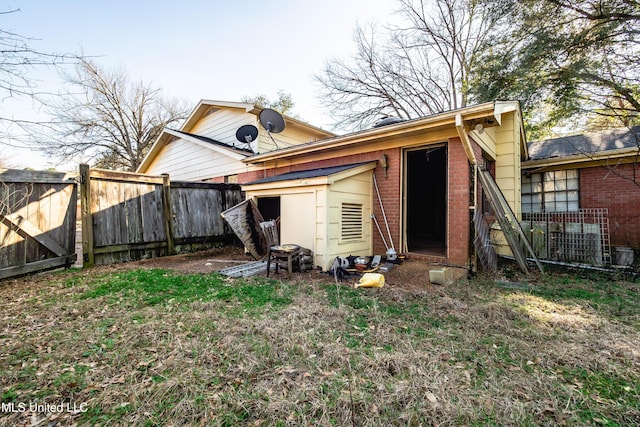 back of property with fence and brick siding