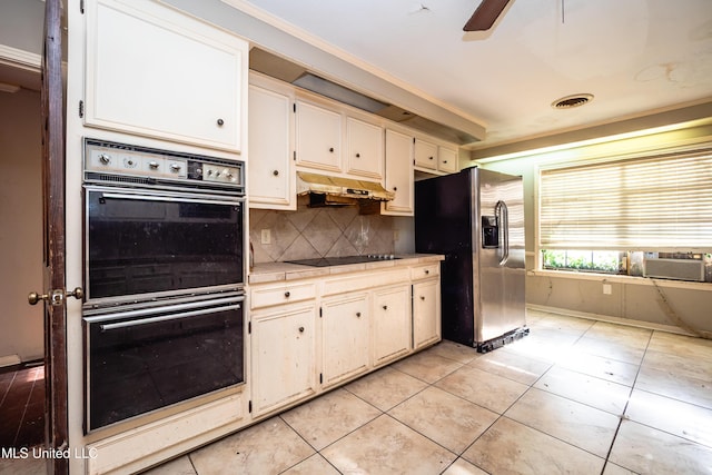 kitchen featuring light tile patterned floors, visible vents, decorative backsplash, under cabinet range hood, and black appliances