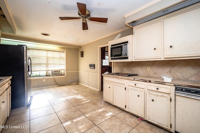 kitchen with light tile patterned floors, ornamental molding, freestanding refrigerator, built in microwave, and tasteful backsplash