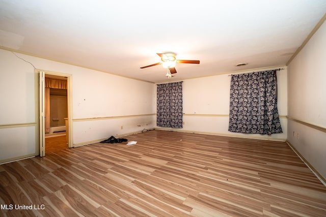 empty room with baseboards, visible vents, a ceiling fan, and light wood-style floors