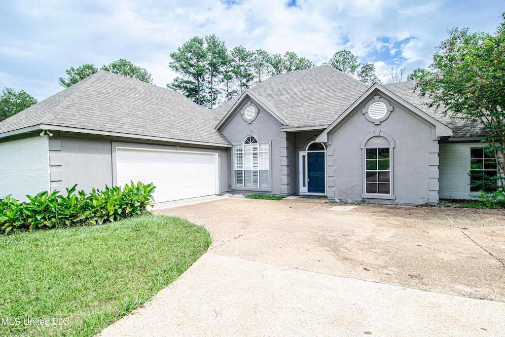 view of front of property with a front yard and a garage