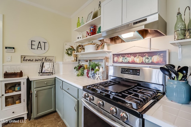 kitchen featuring tasteful backsplash, ornamental molding, tile countertops, and stainless steel gas range