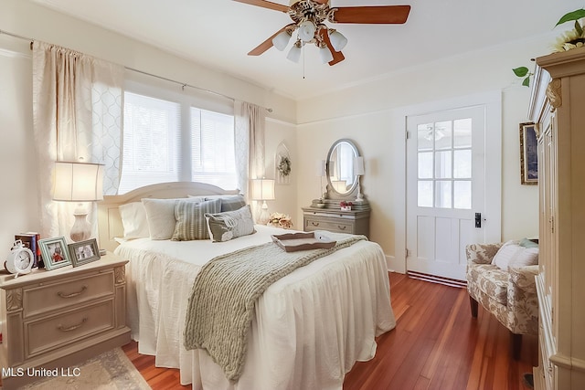 bedroom with multiple windows, wood-type flooring, and ceiling fan