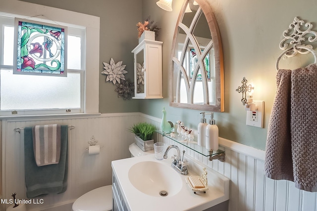 bathroom featuring plenty of natural light, toilet, and vanity