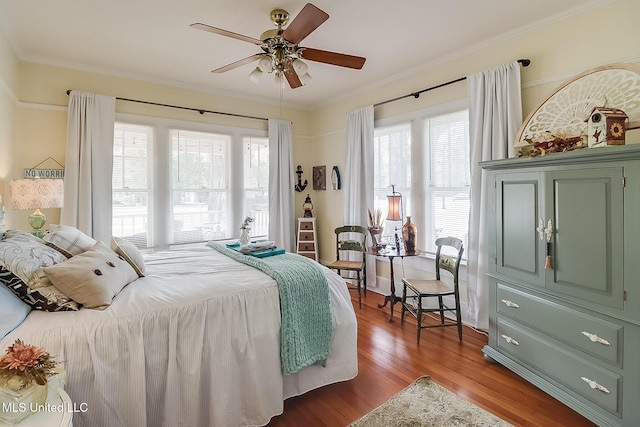 bedroom with crown molding, ceiling fan, and wood-type flooring