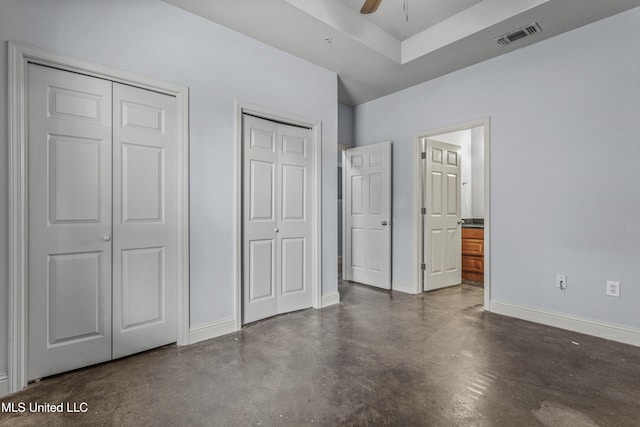 2948 Magnolia Ct, Gulfport, MS 39507 - unfurnished bedroom with finished concrete floors, two closets, baseboards, ensuite bathroom, and ceiling fan