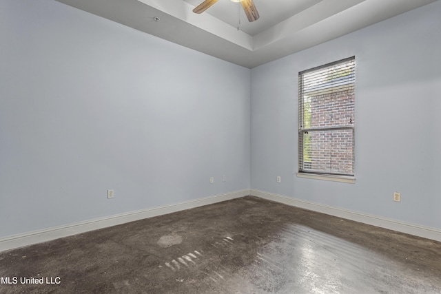 2948 Magnolia Ct, Gulfport, MS 39507 - spare room with baseboards, a tray ceiling, a ceiling fan, and concrete flooring