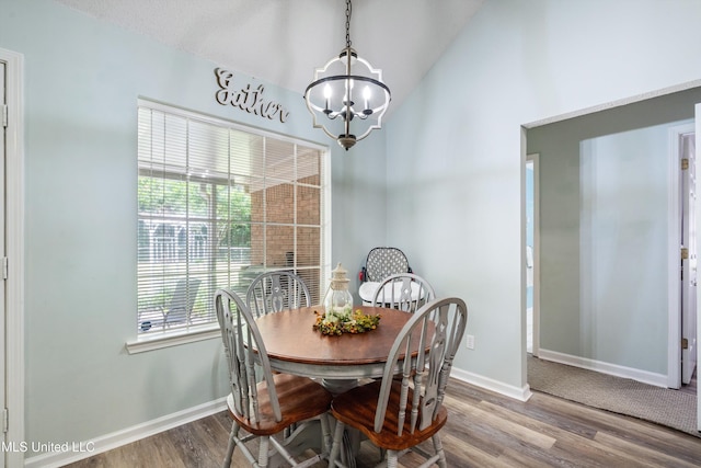 9884 Victor Dr, Olive Branch, MS 38654 - dining room with a chandelier, vaulted ceiling, wood finished floors, and baseboards