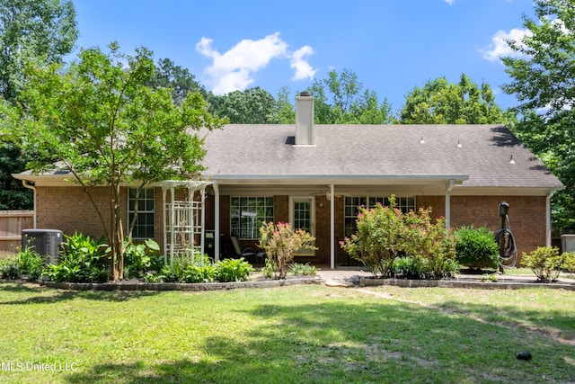 9884 Victor Dr, Olive Branch, MS 38654 - rear view of house with a yard, central air condition unit, a chimney, and brick siding