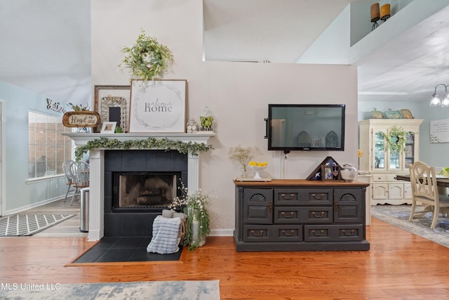 9884 Victor Dr, Olive Branch, MS 38654 - living room with wood finished floors, baseboards, a fireplace, a chandelier, and a high ceiling