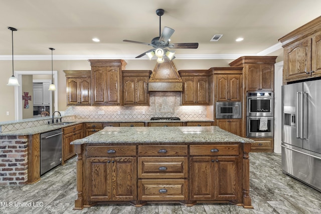 705 Brookwood Cir, Brandon, MS 39042 - kitchen with appliances with stainless steel finishes, a kitchen island, ceiling fan, crown molding, and light stone counters