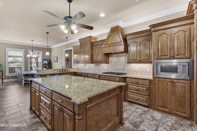 705 Brookwood Cir, Brandon, MS 39042 - kitchen with stainless steel appliances, light stone counters, decorative backsplash, a center island, and ceiling fan