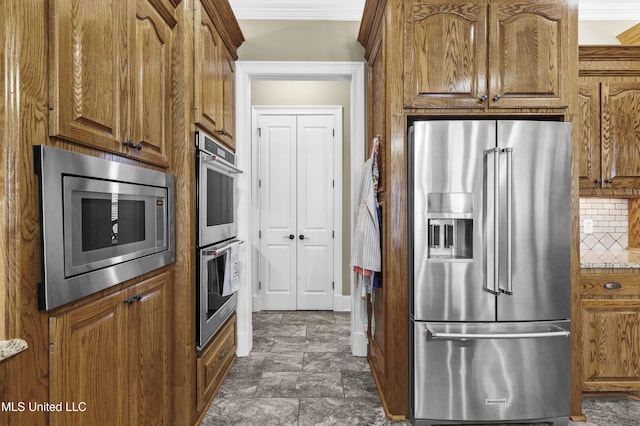 705 Brookwood Cir, Brandon, MS 39042 - kitchen with appliances with stainless steel finishes, brown cabinets, tasteful backsplash, and crown molding