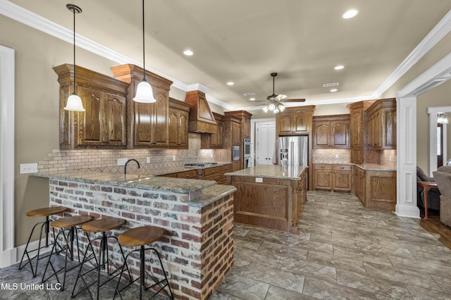 705 Brookwood Cir, Brandon, MS 39042 - kitchen with stainless steel appliances, a ceiling fan, light stone counters, decorative backsplash, and custom exhaust hood