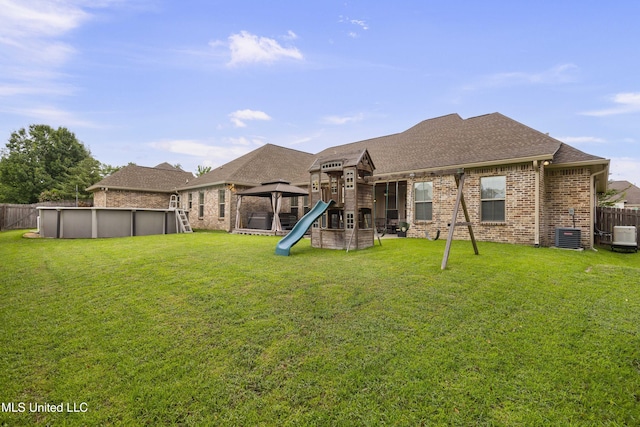 705 Brookwood Cir, Brandon, MS 39042 - back of property with a playground, brick siding, roof with shingles, a gazebo, and central air condition unit