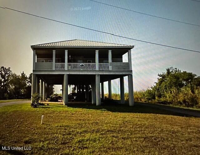 rear view of property featuring a lawn and a carport