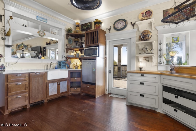 kitchen featuring dark wood-type flooring, white cabinets, crown molding, sink, and butcher block countertops