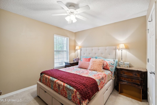 bedroom featuring ceiling fan, light carpet, and a textured ceiling