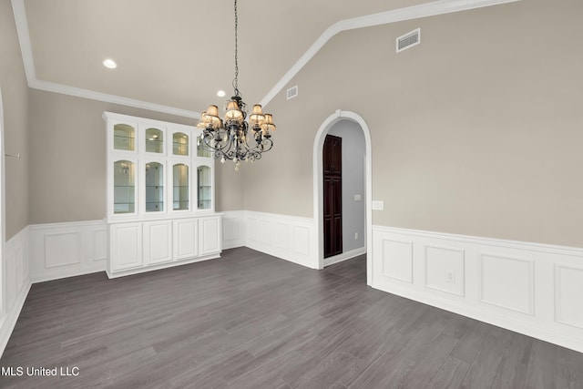 unfurnished dining area with visible vents, dark wood finished floors, an inviting chandelier, lofted ceiling, and arched walkways